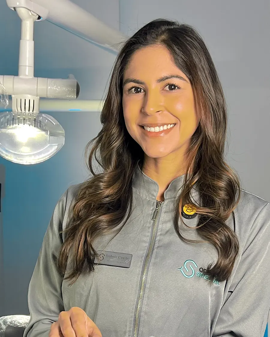 Profissional de jaleco cinza da Odonto Special no consultório, com um alinhador transparente na mão